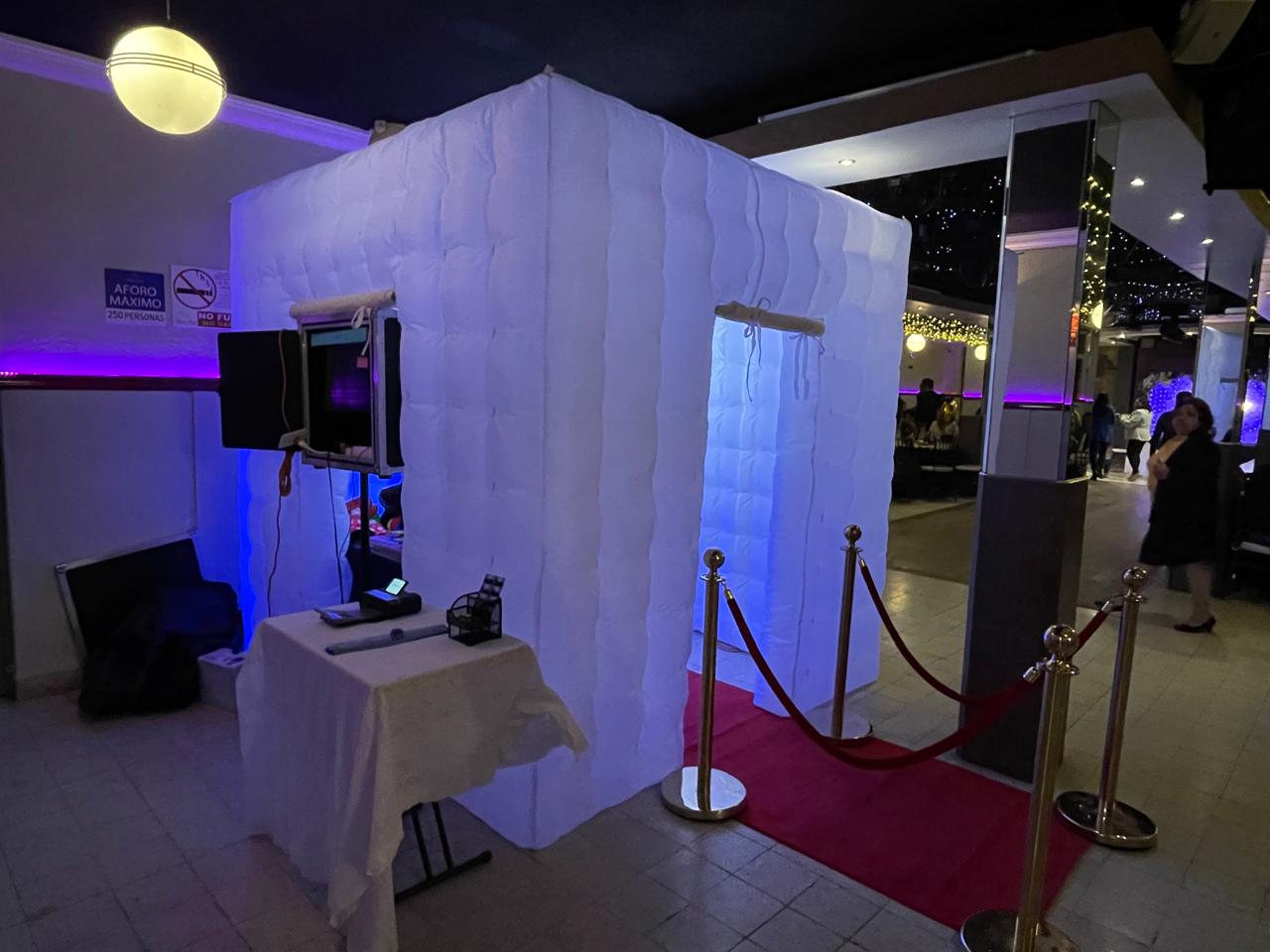 Cabina de fotos inflable blanca iluminada en un evento